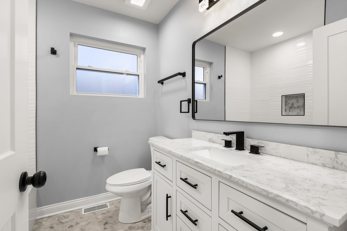 Modern white bathroom with marble countertop and hexagon tile floor